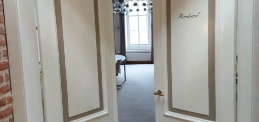 Twee witte deuren die leiden naar de raadzaal van Hattem staan open op een kier. Door deze kier zie je een raam, een kandelaar en een stukje van een vergadertafel.